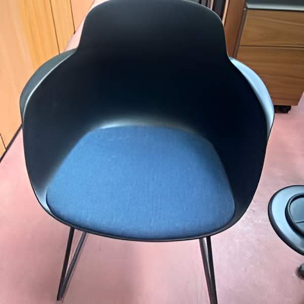 Fauteuil design moderne de marque Infiniti modèle Slica à coque noire, assise en tissu bleu et pieds fins en métal noir. Quantité : 18. 129,00 € HT unitaire.