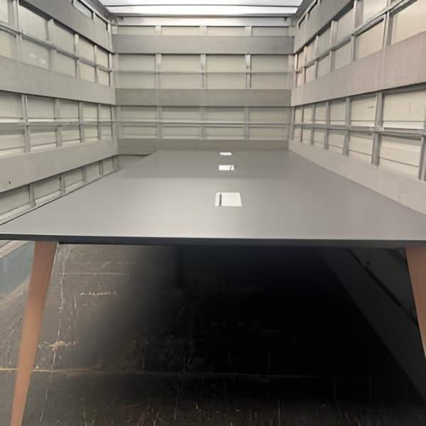 Table de réunion avec plateau anthracite et passages de câbles. 700 x 160 cm. 1 200,00 € HT.
